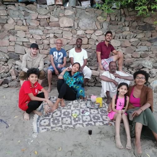 a group of people sitting in front of a picnic table at Go Inn Backpackers in Aswan