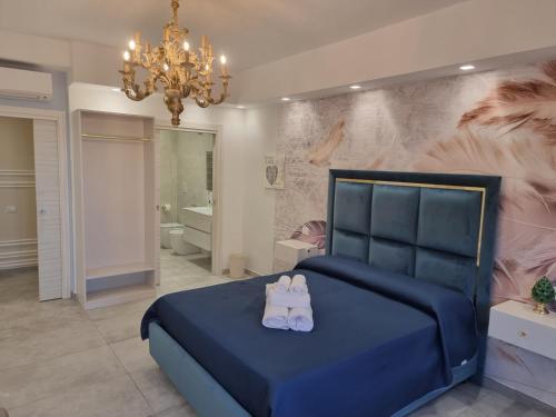 ein Schlafzimmer mit einem blauen Bett und einem Kronleuchter in der Unterkunft B&B al sesto piano in Crotone