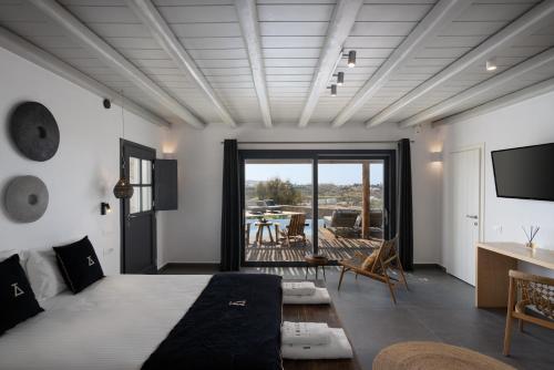 a bedroom with a bed and a desk and a television at Ikies of Mykonos in Mýkonos City