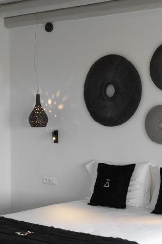 a bedroom with a bed with black and white pillows at Ikies of Mykonos in Mýkonos City