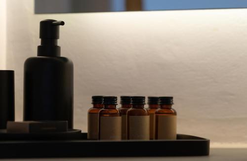 a group of four bottles of sauce on a tray at Ikies of Mykonos in Mýkonos City