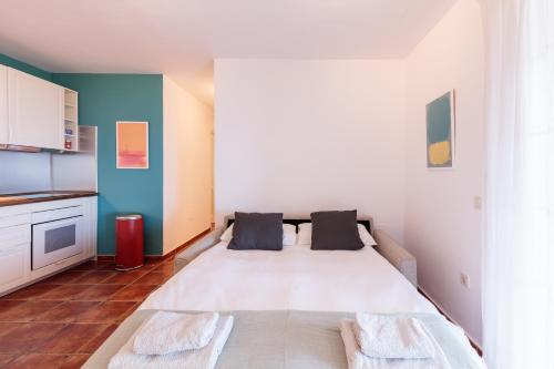 a bedroom with a large white bed with two pillows at La Casita. Atardeceres en Puntagorda in Puntagorda