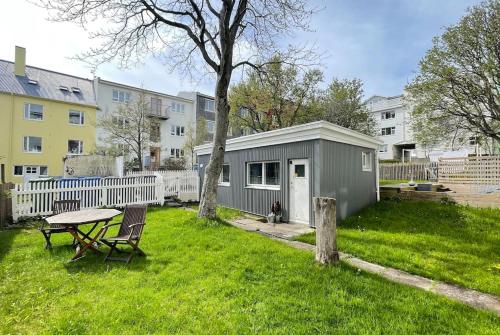 a small shed with a picnic table in a yard at Charming cottage in downtown Reykjavik - Birta Rentals in Reykjavík