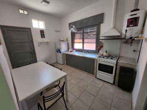 cocina con mesa, fogones y nevera en Departamentos HF, en Villa María