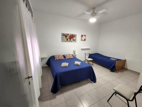 Un dormitorio con dos camas y un ventilador de techo. en Departamentos HF, en Villa María
