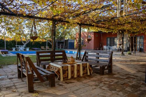 a patio with two benches and a table under a pergola at LA PACHAMAMA in San Juan