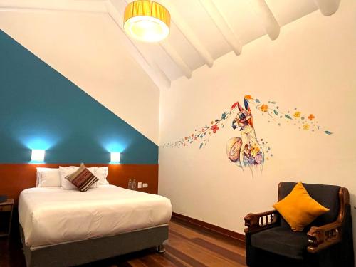Un dormitorio con una cama y una silla en una habitación. en Usgar San Pedro Boutique, en Cusco