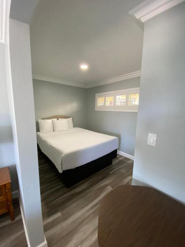 a bedroom with a bed with white sheets and pillows at Lone Oak Lodge in Monterey