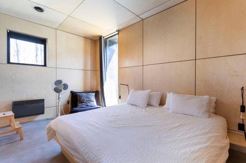 Un dormitorio con una gran cama blanca y una ventana en Cabin Sutton 252 - En harmonie avec la nature!, en Sutton