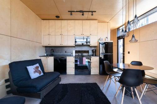 a kitchen with a couch and a table in a room at Cabin Sutton 252 - En harmonie avec la nature! in Sutton