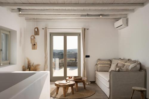 a white living room with a couch and a table at Ikies of Mykonos in Mýkonos City