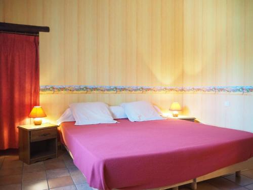 una camera da letto con un grande letto rosa con due lampade di Terraced house, Monteux a Monteux
