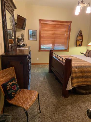 a bedroom with a bed and a chair and a window at THE INN Bigfork Bay in Bigfork
