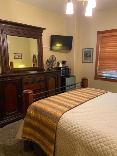 a bedroom with a bed and a dresser and a mirror at THE INN Bigfork Bay in Bigfork