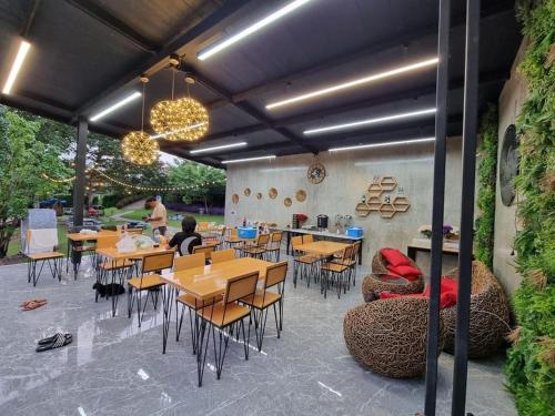 restauracja ze stołami i krzesłami oraz ludzie siedzący przy nich w obiekcie JK Riverview Resort w mieście Ban Song Phi Nong