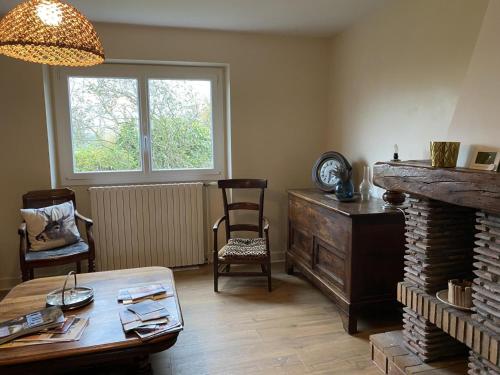 un salon avec une table et une cheminée dans l'établissement Gîte cosy avec terrasse et WiFi - 2 ch, 4 pers à Besson - FR-1-489-355, à Besson