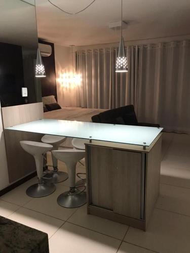a living room with a large white counter and a table at Villas do Pratagy Temporada Limão in Maceió