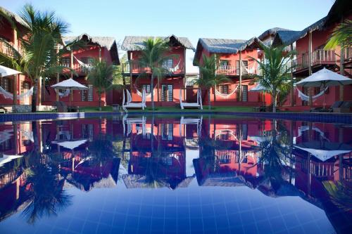 a resort with palm trees and a swimming pool at Long Beach in Canoa Quebrada
