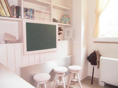 a tv on a wall in a room with stools at Residence Panama in Alassio