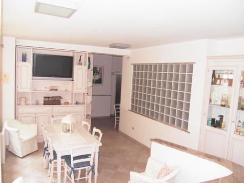 a dining room with a table and a tv at Residence Panama in Alassio