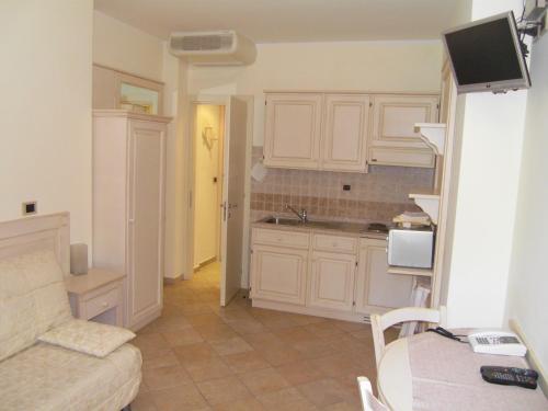 a kitchen with white cabinets and a couch in a room at Residence Panama in Alassio