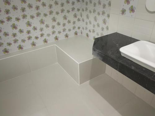 a white bathroom with a sink and a counter at Palm Garden House in Ko Lanta