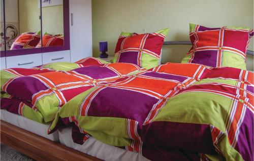 a large bed with a colorful comforter and pillows at Amazing Apartment In Rostock With 1 Bedrooms And Wifi in Rostock