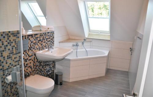 een badkamer met een wastafel, een bad en een toilet bij Golfpark Strelasund in Kaschow