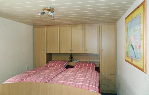 1 dormitorio con 2 camas y armarios de madera en Beautiful Apartment In Remptendorf With Kitchen en Gleima
