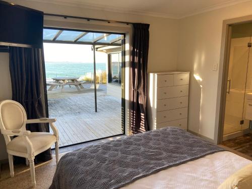 a bedroom with a bed and a view of the ocean at Best Waterfront Deck in Riverton in Riverton