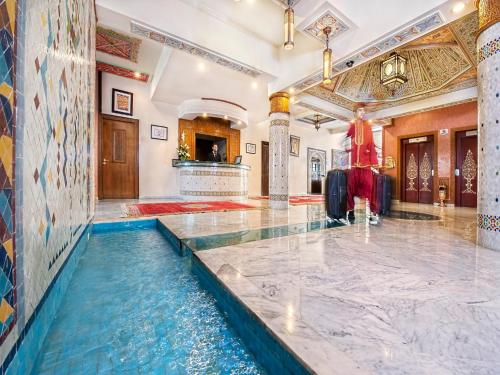 a pool in the middle of a room with a building at Hôtel Club Val d'Anfa Casablanca Ocean view in Casablanca