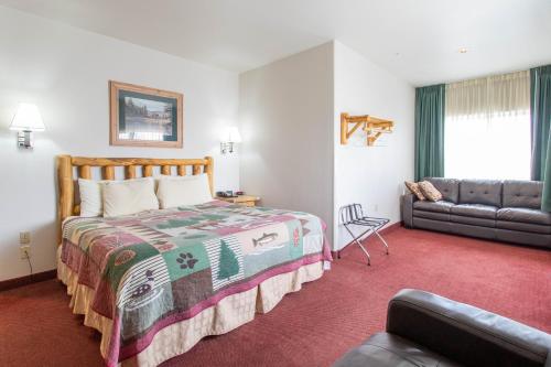 una habitación de hotel con una cama y un sofá en North Park Inn & Suites, en Walden