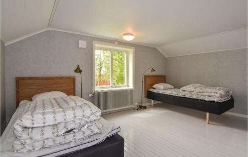 1 dormitorio con 2 camas y ventana en 2 Bedroom Nice Home In motfors, en Åmotsfors