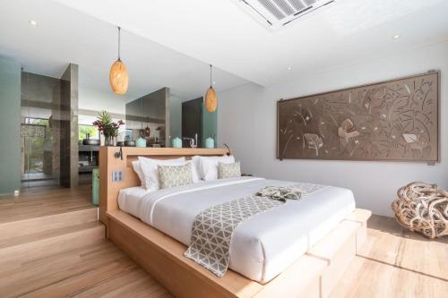 um quarto com uma grande cama branca e uma cozinha em Blue Coral Luxury Villa em Phuket
