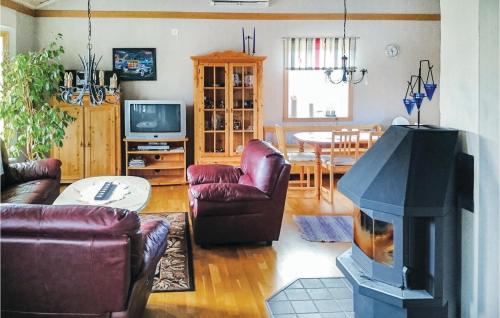 a living room with a living room with a fireplace at Holiday Home Rånnaväg Gällstad in Holmared