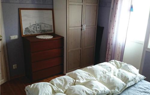 an unmade bed in a bedroom with a dresser at Holiday Home Rånnaväg Gällstad in Holmared