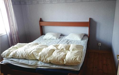 an unmade bed with white sheets and pillows at Holiday Home Rånnaväg Gällstad in Holmared
