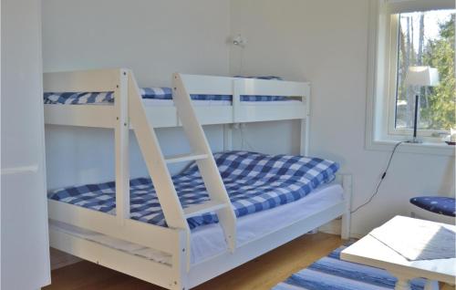 a white bunk bed in a room with a window at Awesome Home In Grisslehamn With Kitchen in Grisslehamn