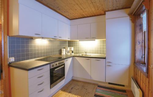 a kitchen with white cabinets and a wooden floor at 2 Bedroom Stunning Home In Sysslebäck in Sysslebäck