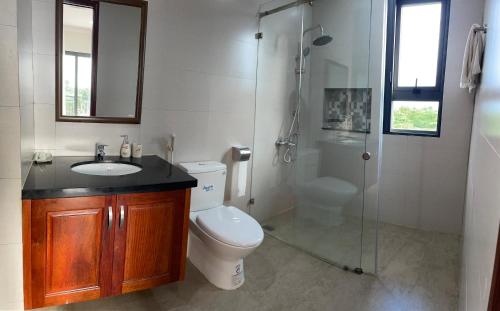 ein Bad mit einem WC, einem Waschbecken und einer Dusche in der Unterkunft SEN VILLA Boutique in Bảo Lộc
