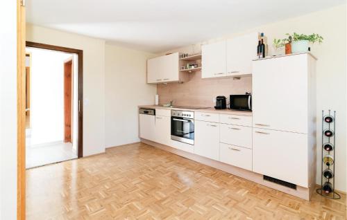 a kitchen with white cabinets and a wooden floor at Schoenes Ferienhaus In Eberau in Eberau