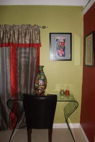 a vase sitting on a glass table next to a window at The Artist Place Villa at Richmond Estates St Ann in Richmond