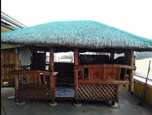 a hut with a grass roof and two chairs at INN D’ZaireH in Molino