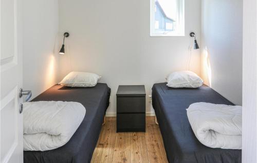 - 2 lits dans une petite chambre avec une table dans l'établissement Beautiful Home In Löttorp With Wifi, à Löttorp