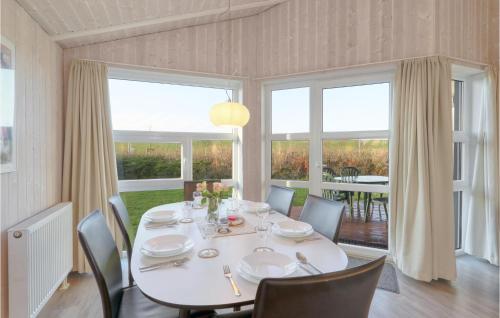 a dining room with a white table and chairs at Friedrichskoog-Strandpark 9 in Friedrichskoog