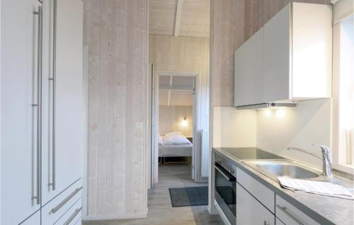 Il comprend une chambre et une cuisine avec des placards blancs et un évier. dans l'établissement Friedrichskoog-strandpark 9, à Friedrichskoog
