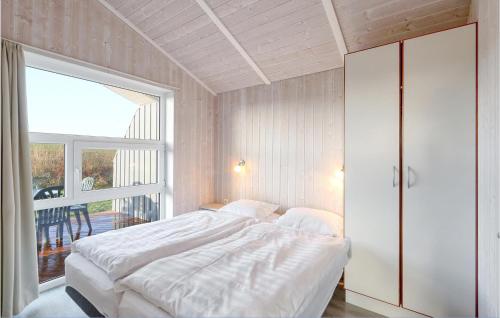 - une chambre avec un grand lit blanc et une fenêtre dans l'établissement Friedrichskoog-strandpark 9, à Friedrichskoog