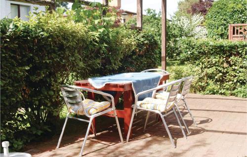 une table avec trois chaises ainsi qu'une table et des chaises bleues dans l'établissement Holiday Home Mölschower Weg Y, à Trassenheide