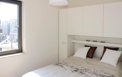una camera bianca con un letto e una finestra di Residentie Crystal Ref 93 a Ostenda