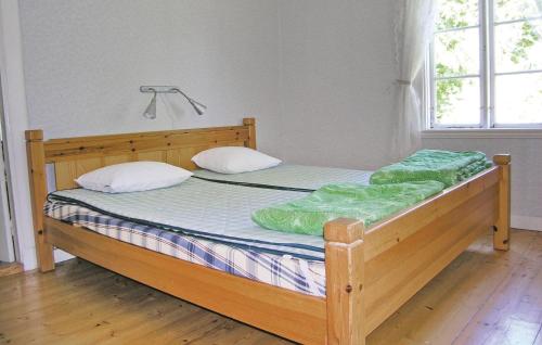 1 dormitorio con 1 cama de madera y 2 almohadas en Stunning Home In Lnashult With Kitchen, en Tvetaryd